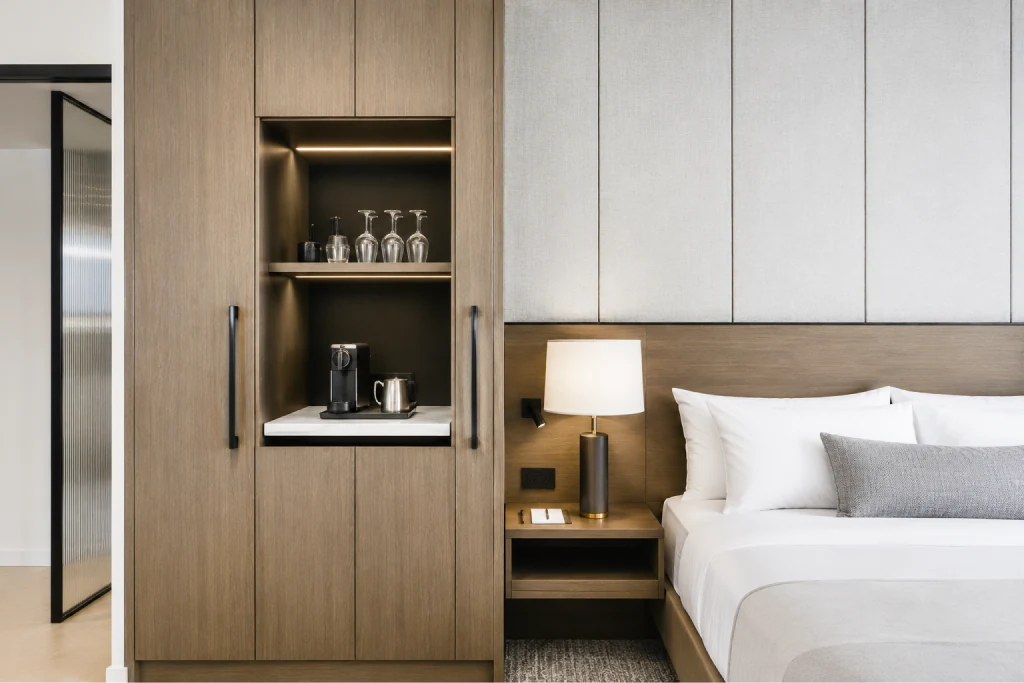 Boutique hotel room with built-in wood millwork, wardrobe and bedside unit