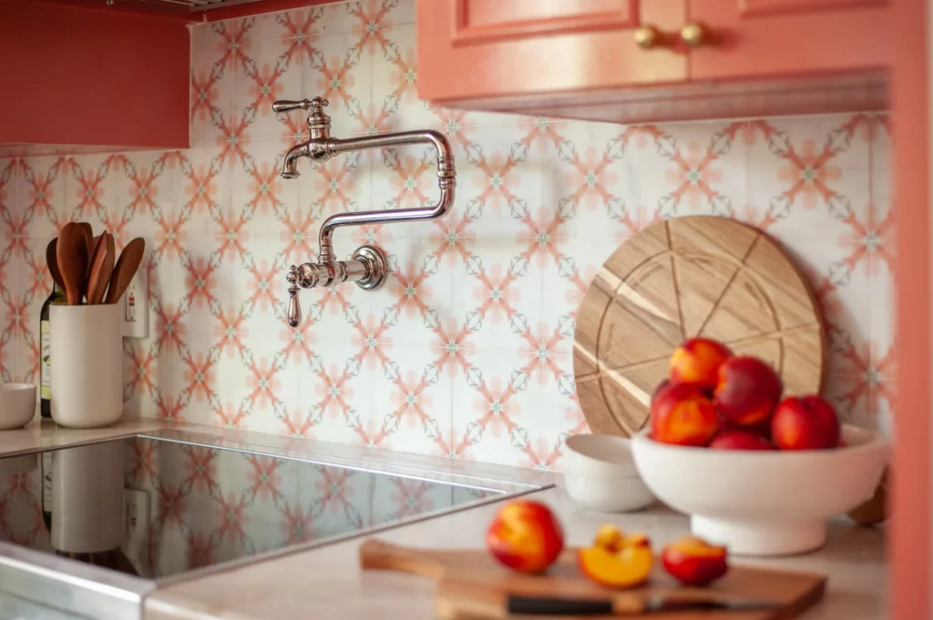 Coral shaker cabinetry with brass pulls around a stainless range, Sanford