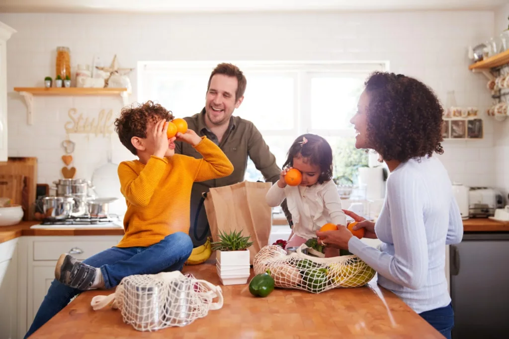 Family sharing oranges in a bright kitchen