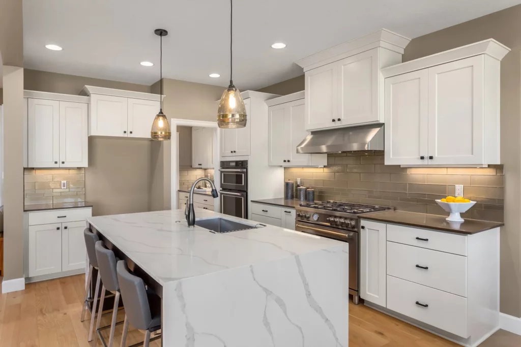 White kitchen with large island and integrated appliances