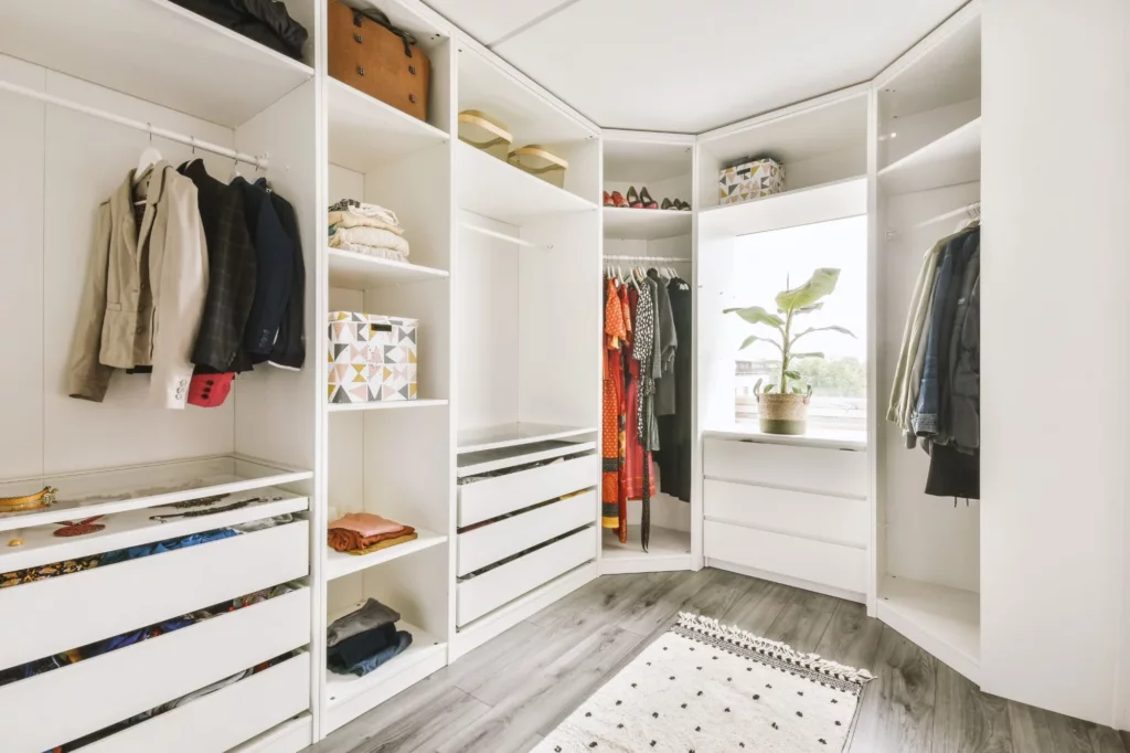 White walk-in closet with hanging rails, shelving and drawers
